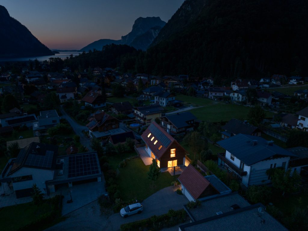 Wohnsiedlung bei Nacht: Mit Notstrom durch Photovoltaik erzeugtes, beleuchtetes Haus