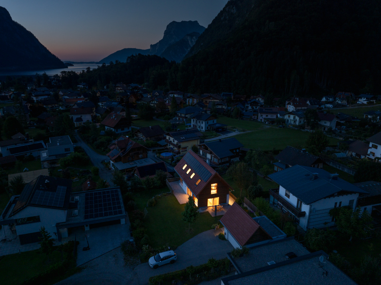 Wohnsiedlung bei Nacht: Mit Notstrom durch Photovoltaik erzeugtes, beleuchtetes Haus