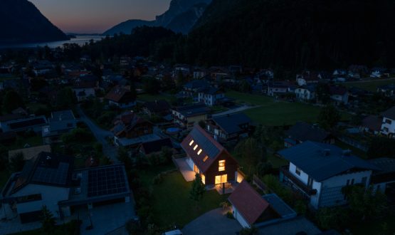 Wohnsiedlung bei Nacht: Mit Notstrom durch Photovoltaik erzeugtes, beleuchtetes Haus